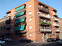 Bloque residencial en Madrid con balcones y persianas verdes con certificado ITE